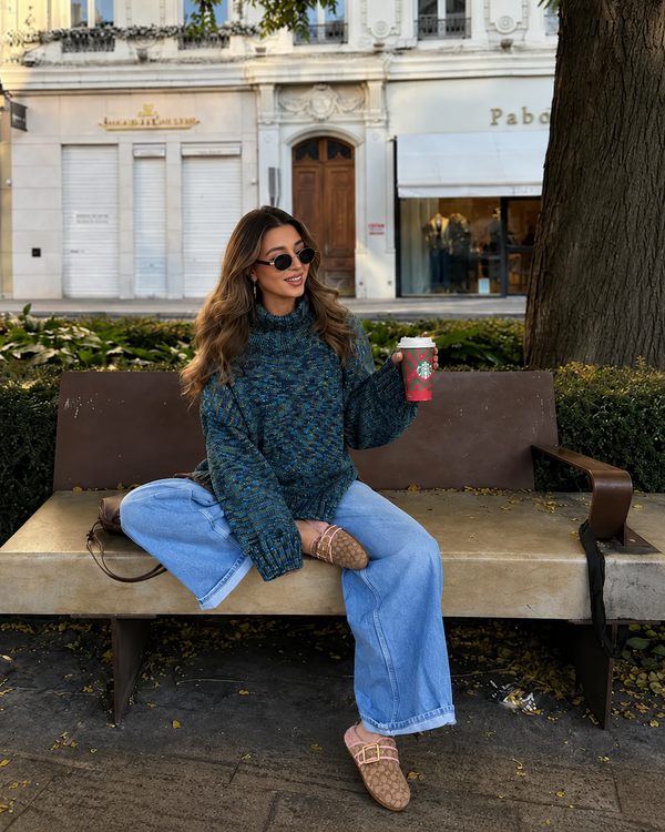 Khaki Pink Ashton clogs styled with a blue sweater and jeans on a bench