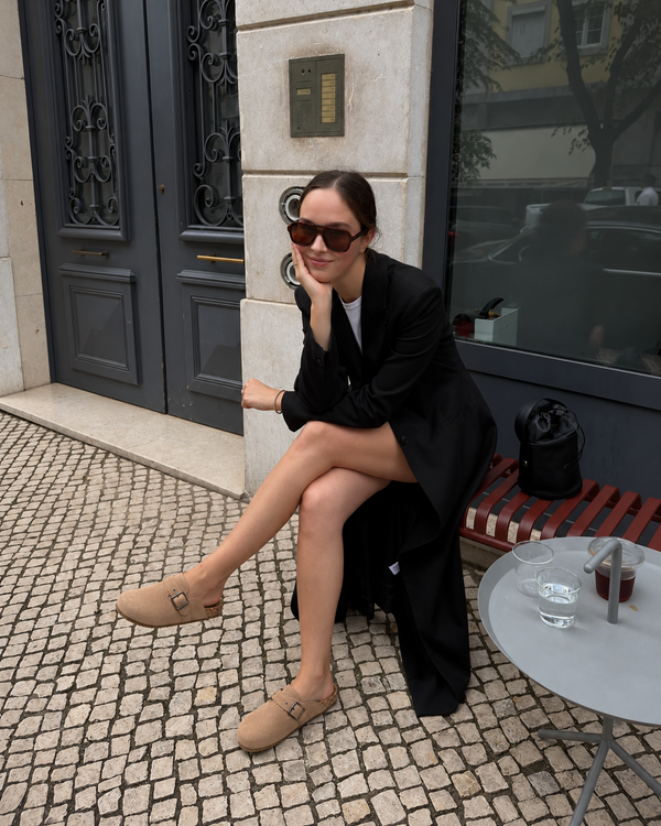 Tan Ashton clogs styled with a black blazer and skirt at a cafe